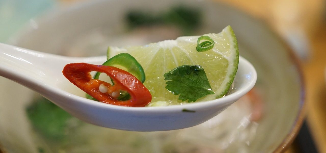 Close-up of a spoonful of pho garnished with lime, chili, and cilantro at 98 Center in Moab, Utah.